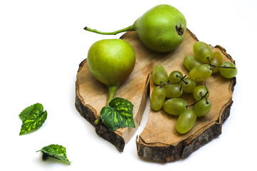 A bunch of grapes and wild pears on a wooden board on a white background. Close-up