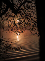 Autumn sunrise by a foggy lake