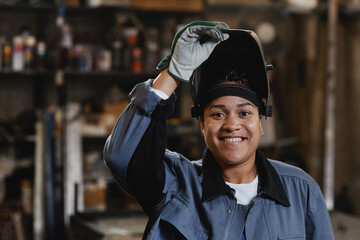 Fototapeta Closeup portrait of smiling female welder looking at camera in industrial factory, copy space obraz