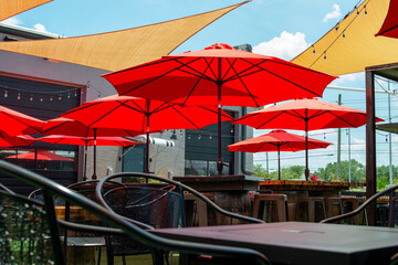 Multiple triangle shaped yellow nylon sunshades and awnings hanging over a patio deck. There are...