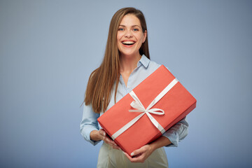 Woman holding gift box. Isolated female portrait on blue background.