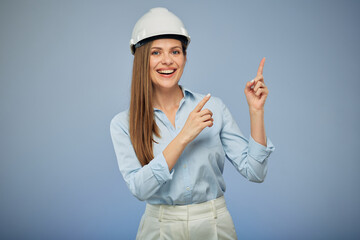 Woman architect or engineer in safety industrial helmet pointing with fingers up. Isolated female portrait.