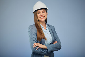 Smiling woman architect or engineer in safety helmet standing with arms crossed. Isolated female portrait.