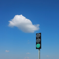 Green traffic light for road works with blue sky and white cloud