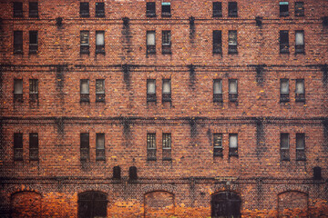 Wall of the old factory building of red brick with narrow windows