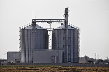 Modern cereal drain buildings on the farm . Countryside industrial landscape © Ilya