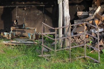 Old plow and harrow for motor tiller on old shed background . Rural farm
