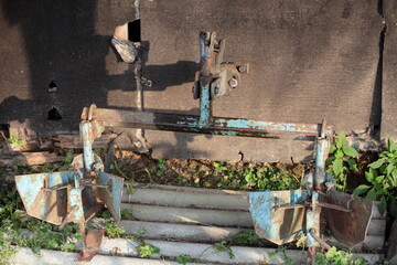 Old plough for motor tiller on old shed background . Rural farm