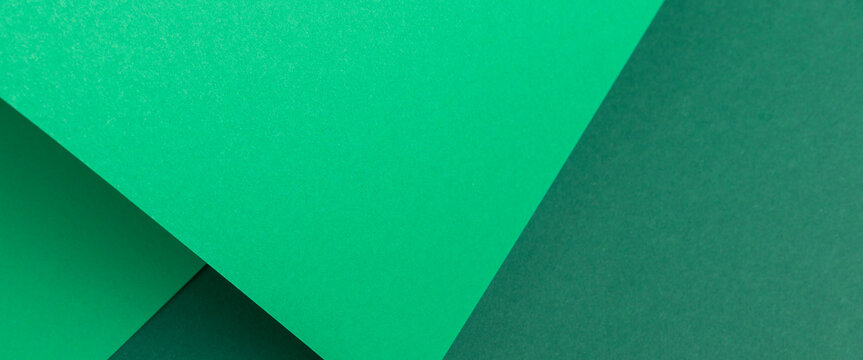 Green cardboard background design folded geometrically. Top view, flat lay. Banner