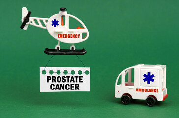 On a green surface, an ambulance car and a helicopter with a sign - PROSTATE CANCER