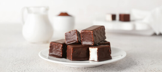 Plate with tasty bird's milk candies on light table