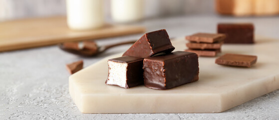 Board with tasty bird's milk candies on table, closeup