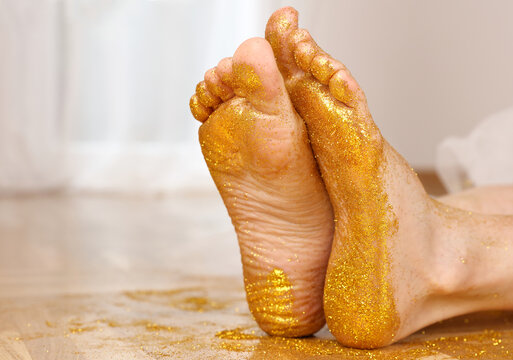 Golden glitters on female bare feet. Follow your dreams, choose your own way.