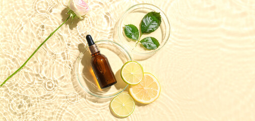 Bottle of citrus essential oil, flower and fruits slices in water on light background, top view