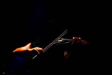 Closeup of man playing violin on stage