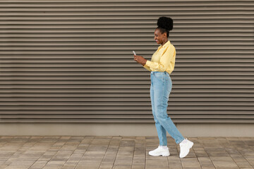 Happy Black Woman Using Phone Standing In Urban Area Outdoors