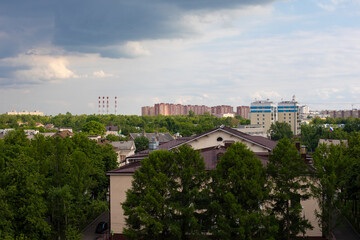 Fototapeta na wymiar View of the city of Vidnoye, Moscow region Russia from the Ferris wheel in the city park. Shkolnaya street and administrative building shrouded in greenery.