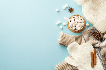 Top view photo of knitted hat mittens sweater mug of hot drinking with marshmallow on rattan...