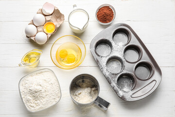 Different ingredients for baking on white wooden background