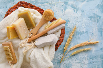 Basket with bath supplies and spikelets on color background