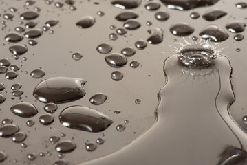 Macro splash, macro photo of a drop of water falling on a reflective surface, selective focus.