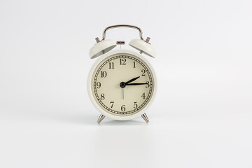 White retro clock alarm clock on white background shows 02:15 am or 02:15 pm or 14:15