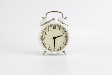White retro clock alarm clock on white background shows 02:30 am or 02:30 pm or 14:30