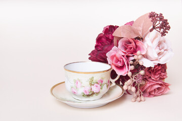 Romantic rose flowers with antique tea cup and saucer