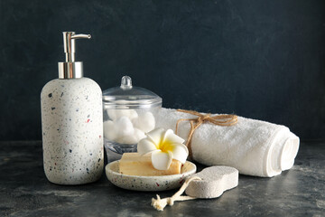 Set of bath supplies with towel on dark background