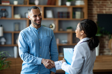 Cheerful african american woman doctor greeting male patient