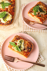 Plates of tasty Italian pie with mozzarella and pesto sauce on light table