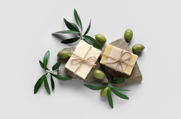 Composition with soap bars, green olives and leaves on white background