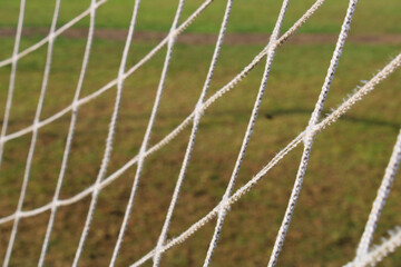 The grid from the old football goal close-up on the background of the football field