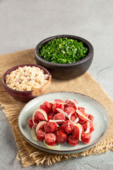 Sliced sausage with onion, green cabbage and farofa.