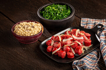 Sliced sausage with onion, green cabbage and farofa.