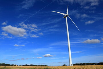 Fototapeta premium Wind power turbines at a meadow. Windy weather one summer day outside. Modern Swedish farm land. Near Skara, Sweden, Scandinavia, Europe. Year 2022.