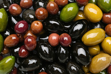 Different kinds of fresh olives as background