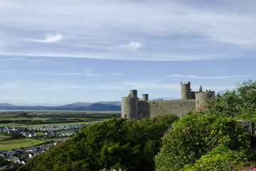Fototapeta na wymiar Harlech Castle, Wales. Landscape view of a UNESCO monument. Beautiful Welsh world heritage site. Fortification of Edward 1 of England. Blue sky and copy space.