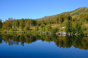 Fototapeta na wymiar Lakeside trees and reflections in Autumn, Geilo, Norway