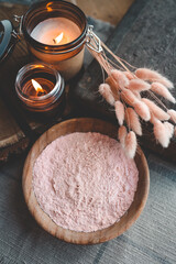 Bath powder in wooden bowl and candles, care and relaxation concept.