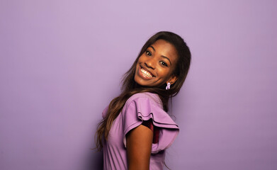 Happy Afro woman smiling, has good mood isolated on studio purple background.