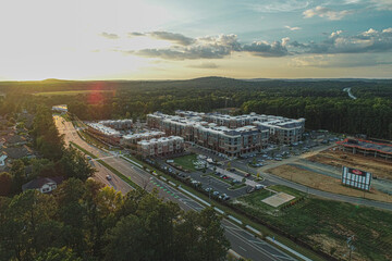 apartment complex from aerial drone perspective at sunset near a construction site and highway view