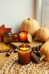 Fototapeta na wymiar Burning candle and autumn decor, home decor aesthetics