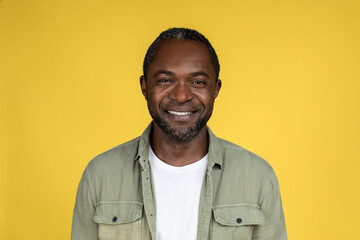 Headshot of smiling confident adult african american male in casual looking at camera