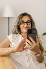 Female using smartphone and taking pictures at home