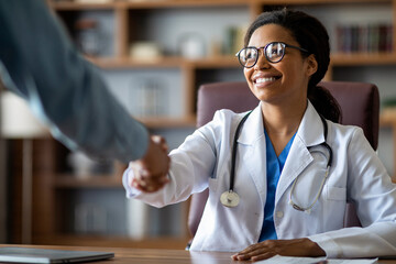 Cheerful african american woman doctor shaking patient hand
