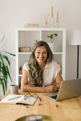 Mature happy woman sitting and looking at the camera