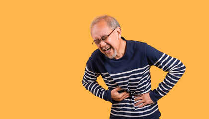 Asian senior man wearing glasses standing face expression with a stomachache isolated on yellow background.