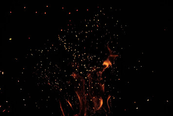 blurred sparks particles from fire in front of black background