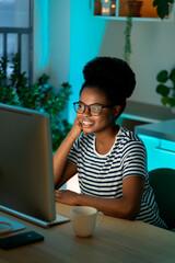 Happy smiling designer girl enjoy working from home on new remote project. Successful african web...